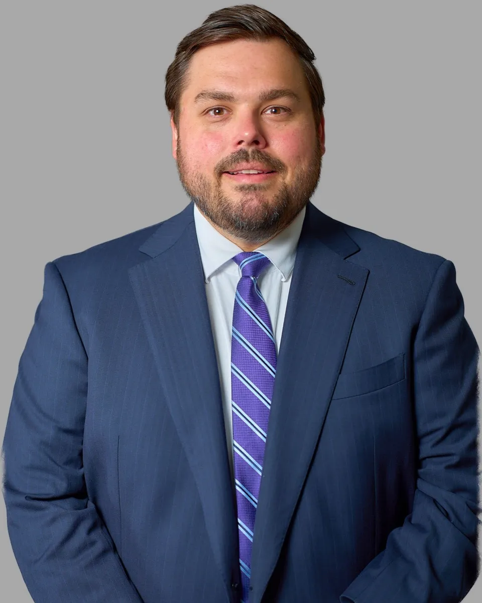 Portrait of attorney Michael McDonald in a navy suit and striped tie